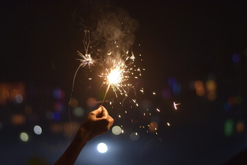 Woman holding a sparkler out. Diwali, New Year's Eve, Christmas party or birthday celebration