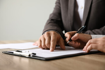 Businesspeople working with document at table indoors, closeup. Space for text