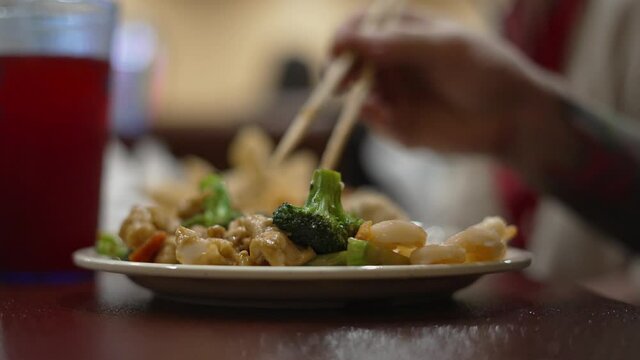 Tattoo Armed Man Eating Broccoli Chicken And Shrimp With Chopsticks At Chinese Buffett Restaurant Indoors After Covid 19 Lockdown Restrictions Were Lifted, In 4k 60fps Real Time.