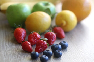 Various colorful fruit on wooden background. Selective focus.