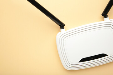 White wi-fi router with black antennas on beige background with copy space. Minimalism
