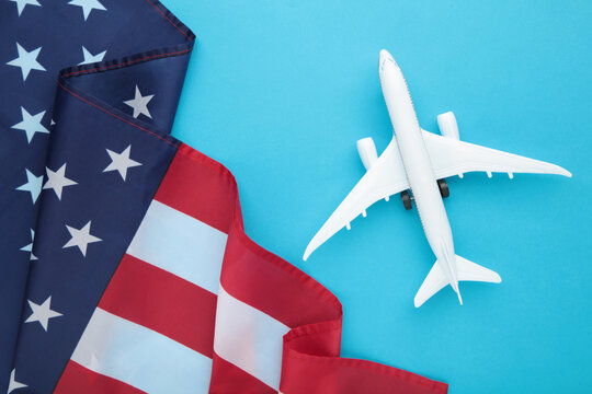 Toy plane with american flag on blue background. Travel