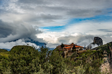 Fototapeta na wymiar Greece, Meteora, green panoramic landscape with one of the monasteries. Impressive dramatic sky.