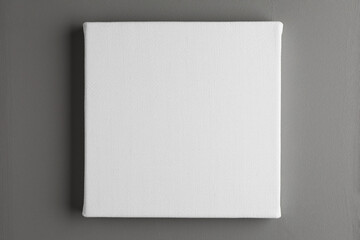Blank canvas hanging on grey wall, space for text