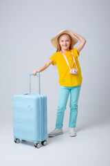 little girl traveler with a suitcase on a white background