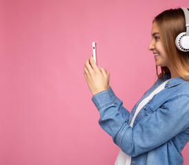 Side-ptofile closeup photo of beautiful smiling happy young woman wearing stylish casual outfit...