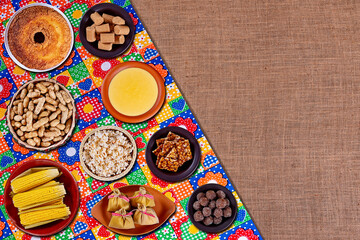 Brazilian june party. Typical foods of the June festival. hominy, boiled corn, corn cake, popcorn, broccoli, paçoca, genipapo and peanuts. Top view with copy space