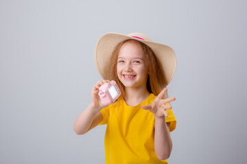 little girl in hat traveler holds a camera on a white background