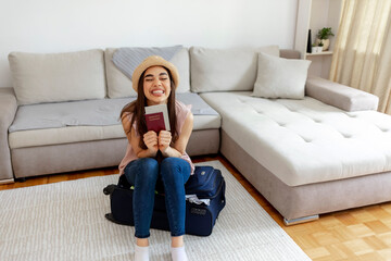 Obraz premium The young woman is excited for her first vacation after a long time, due to a global problem caused by the Coronavirus. Smiling woman holds tight herd immunity passport and vaccine certificate in hand