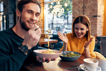 cheerful man and woman sitting in a cafe communicating emotions