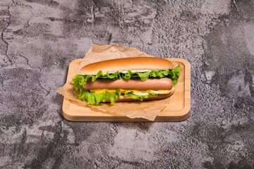 Delicious homemade hot dog with cucumber, tomato and onion on a concrete background.Hot...