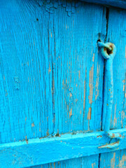 texture of old painted shabby rustic wooden fence made of planks, with rusty nails, hand-forged iron elements, grunge background