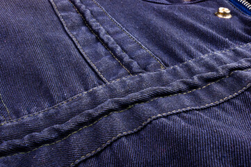 clothing items stonewashed cotton fabric texture with seams, clasps, buttons and rivets, macro