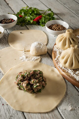 Close up to Caucasian khinkali dumplings dish served on plate. Background with ingredients and scattered spices