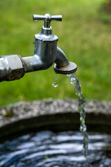 close-up of a faucet with running water outside