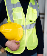close up of worker with safety helmet in hand