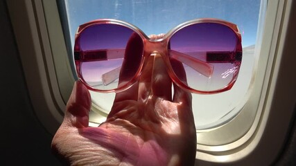 Flight above Turkey - 16th of May 2021: 4K Holding sunglasses against cabin window during flight
