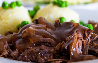 beef meat with gravy, mashed potatoes with green peas