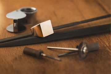 Blank logo ring, empty sterling golden ring, signet ring, initial ring and jeweler tools on wooden...