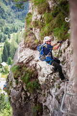 climbers in full equipment climb Slovenian ferrates