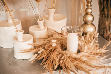 Natural interior decor, table, candlesticks with candles and dry herbs