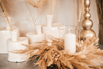 Natural interior decor, table, candlesticks with candles, dry herbs
