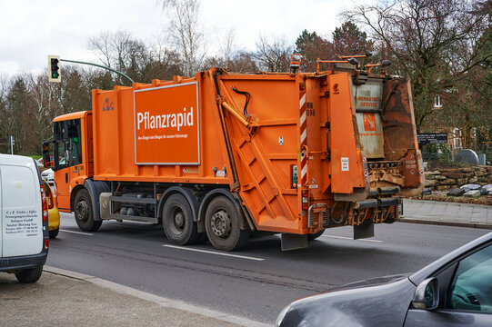 Berlin, Germany - March 11, 2020: Street scene with a truck of the Berlin city cleaning. On the side of the truck you see a sign that humorously advertises the conversion of organic waste into biogas.