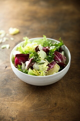 Healthy mixed green salad in a white bowl