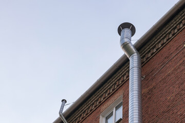 New ventilation metal pipe in a brick house