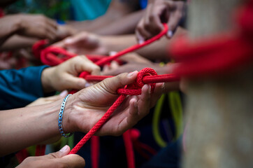 man tying a knot in a climbing rope.