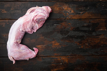 Fresh raw rabbit meat, on old dark  wooden table , top view flat lay, with copy space for text