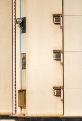 Fototapeta premium Windows and air condition units on the walls of a residential skyscraper in suburban Mumbai.