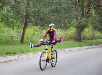 funny portrait of an emotional girl in a helmet on a bicycle in motion. having fun riding a bike...