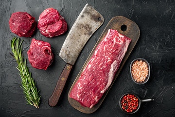 Gourmet portion of raw fresh marbled beef fillet , with old butcher cleaver knife, on black stone...