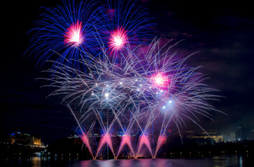 Creative firework display over water and the skyline  at the International Sound of Light fireworks competition (Les Grands Feux du Casino Lac-Leamy)