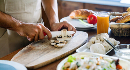 Cooking, food and people concept. Close up of male hand cutting ingredient