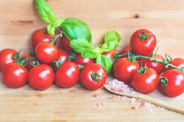 Red Cherry Tomatoes with Basil  on a Wooden Background 