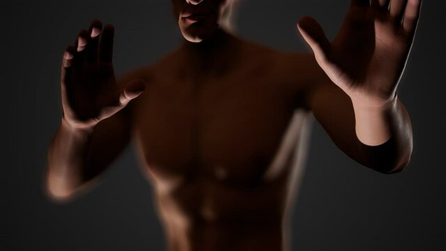 Handsome muscular shirtless young man standing in the dark