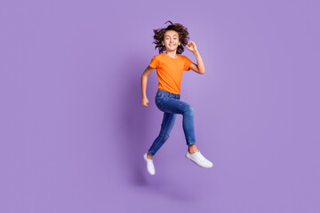 Fototapeta na wymiar Full length body size view of attractive cheerful boy jumping having fun running isolated over violet purple color background