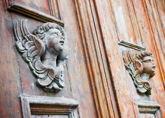 Sculpture of a wooden angel on a old italian door (Italy) - more than a hundred years old