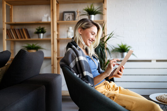 Happy young woman using tablet pc in loft apartment - Powered by Adobe