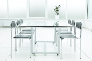 Black chairs glass table in bright office space