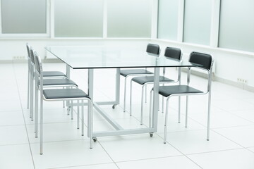 Black chairs and glass table in bright office space