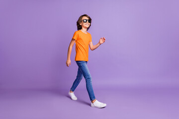 Fototapeta na wymiar Full length body size view of attractive funky glad cheerful boy strolling isolated over violet purple color background