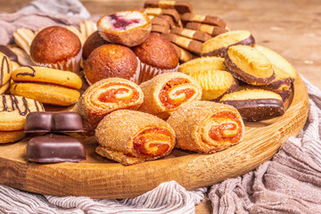 Assorted various cookies and muffins in wooden combination plate