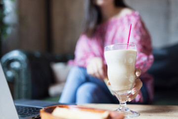 Pretty young asian woman drinking iced coffee in modern cafe. 