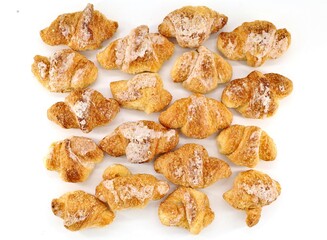 Top view of a group of glazed mini croissant on white background.