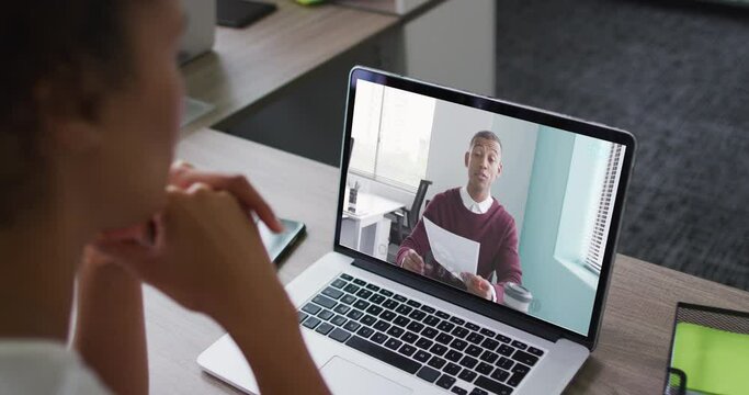 African american woman having a video call on laptop with male colleague at office