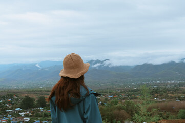 Fototapeta na wymiar Young women thihking and look at view of the mountain ,calm and mindfulness concept
