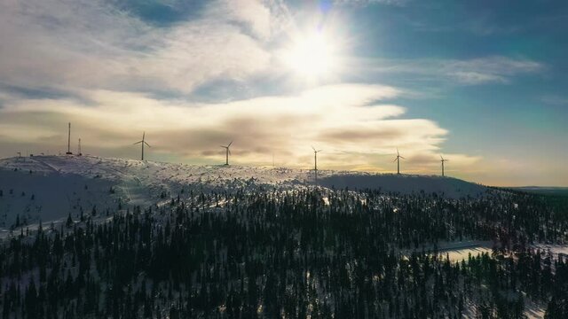 Aerial view of windmills on top of a mountain, golden hour, in Lapland - reverse, drone shot